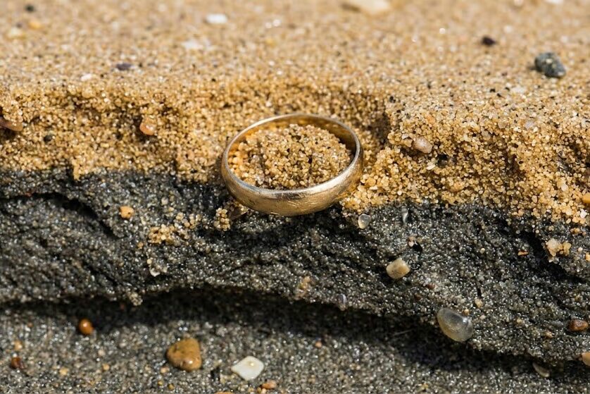 Cross-section view of beach sand layers showing how heavy gold and silver targets sink to hardpan during low tide sorting